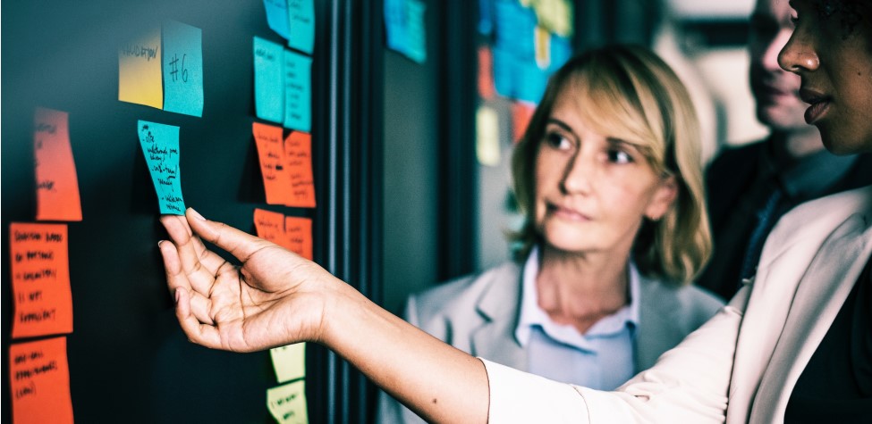 Office workers looking at notes on wall